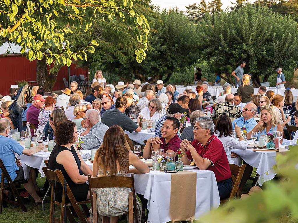 people dining outdoors surrounded by greenery