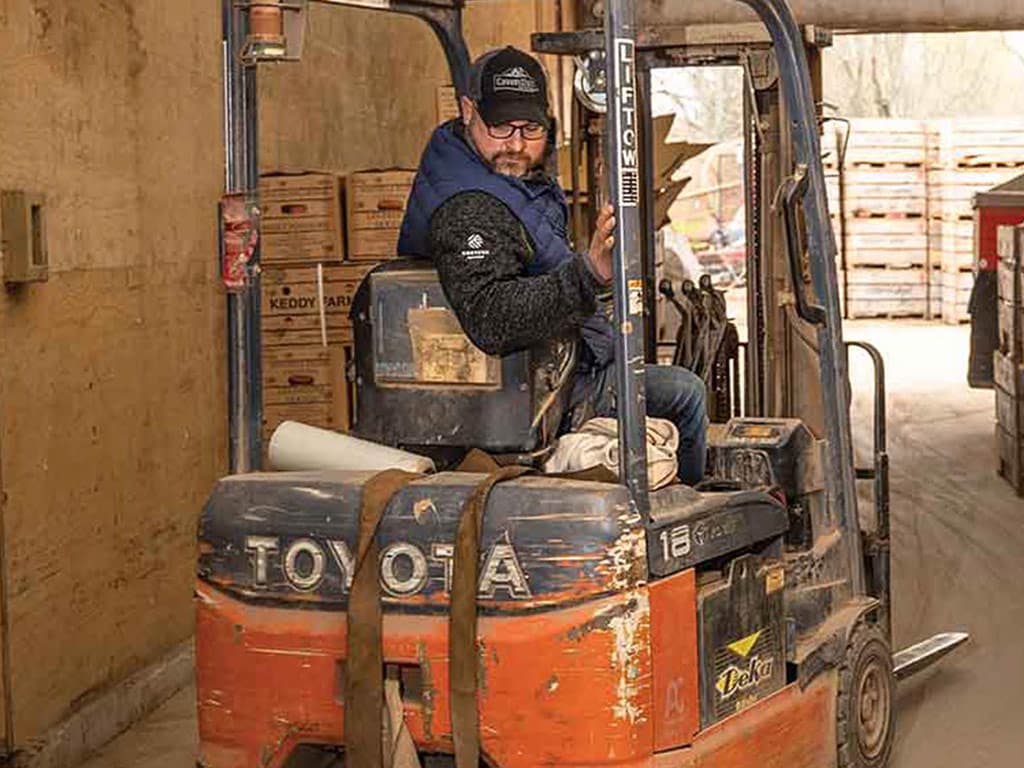 man backing up in forklift in a warehouse