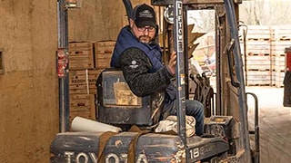 man backing up in forklift in a warehouse