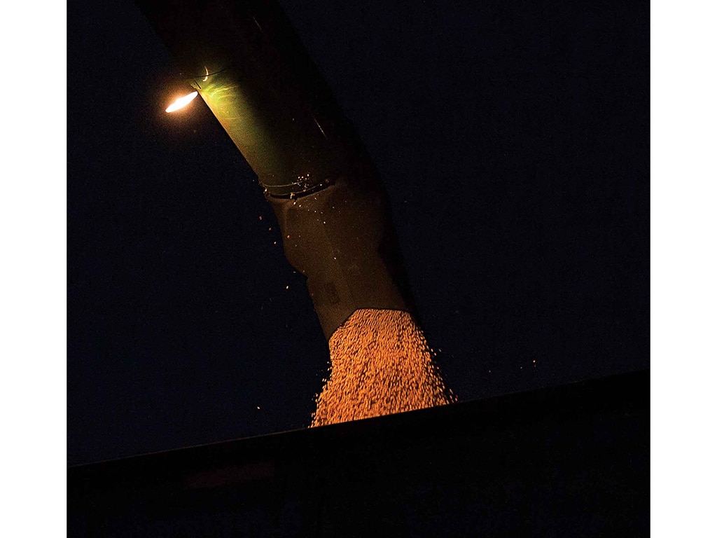 grains loading on to semi in the dark under a spotlight