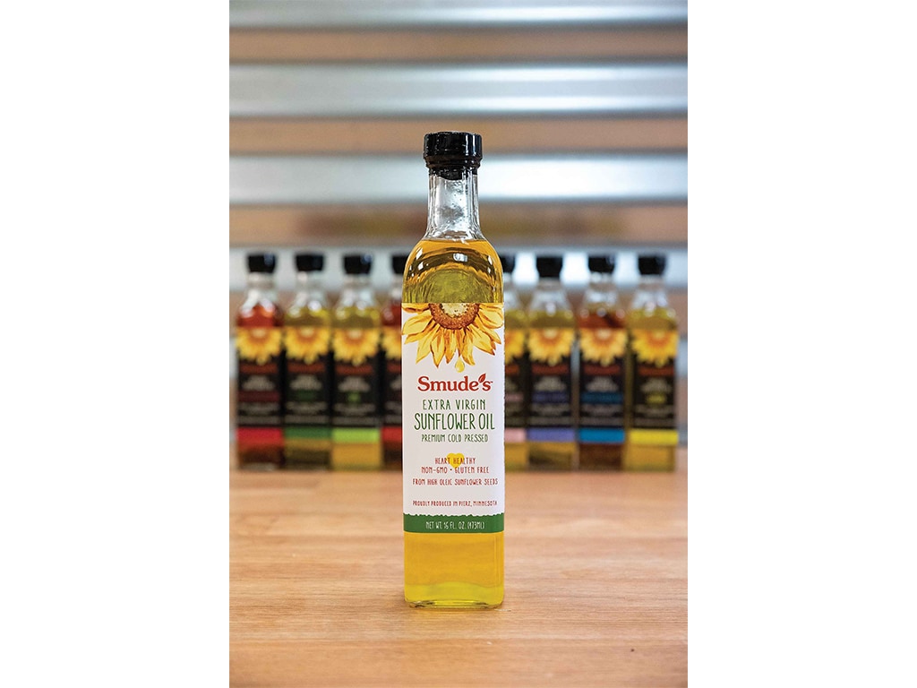sunflower oil on a wood table in front of several other blurred products in the background