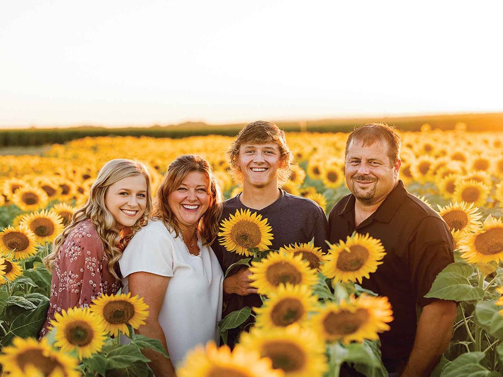 Family posing at dusk in a field of sunflowers