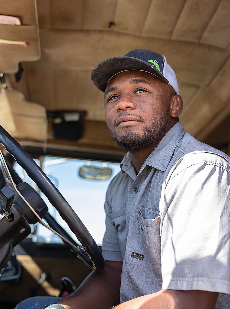 man in truck cab with baseball cap on