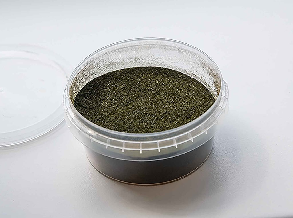 plastic container full of green powder with lid