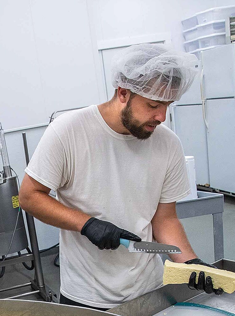 man cutting cheese over sink