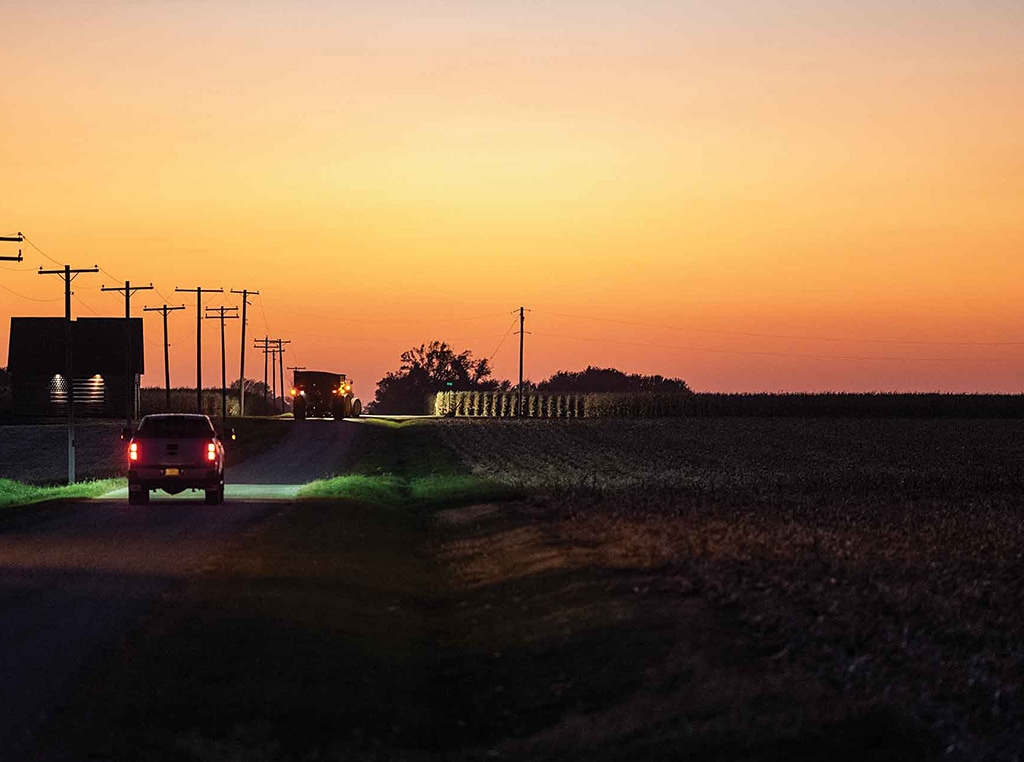 country road at dusk with trucks taillights illuminated