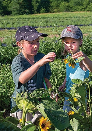 two girls playing with flowers