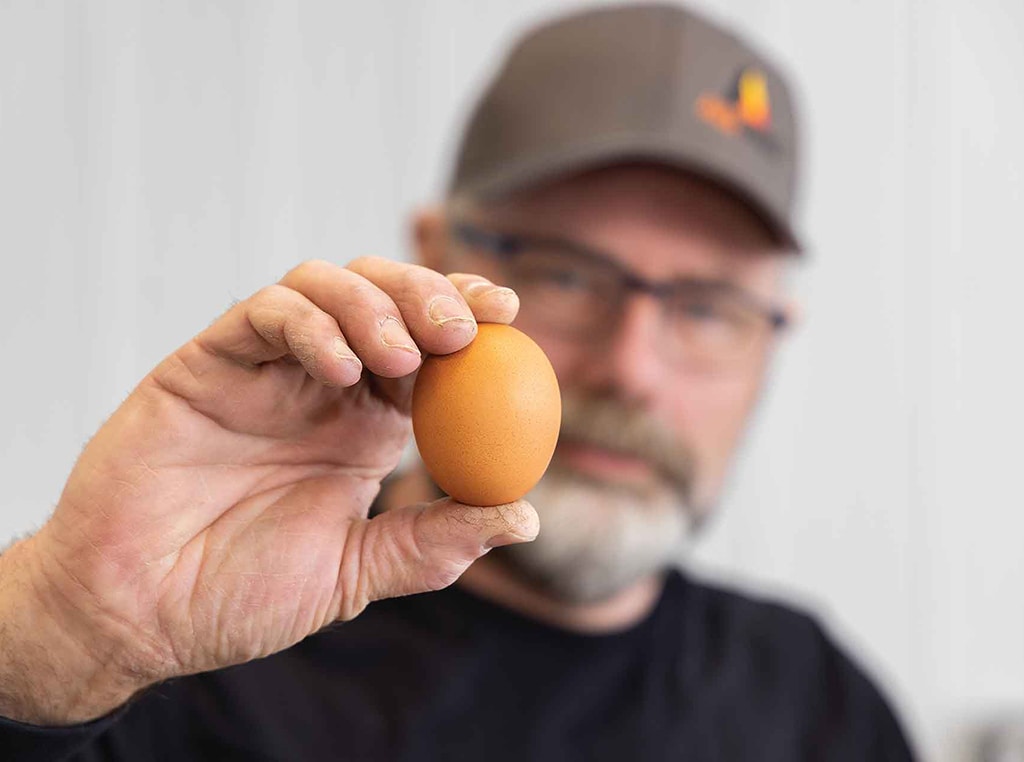 closeup of egg held by man blurred in background