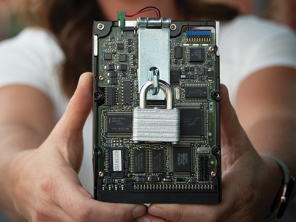 Person holding a computer chip with a metal lock on it