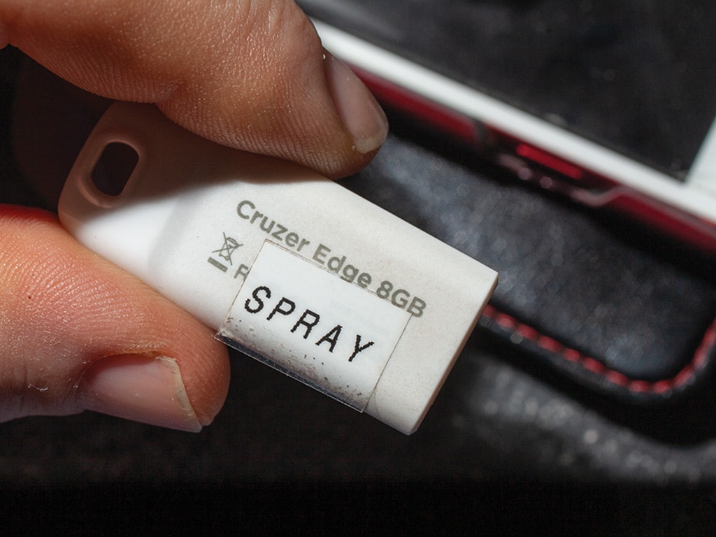 closeup of white flash drive with sticker with the word spray on it