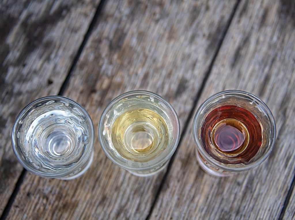 top view of three shot glasses with different colored liquors