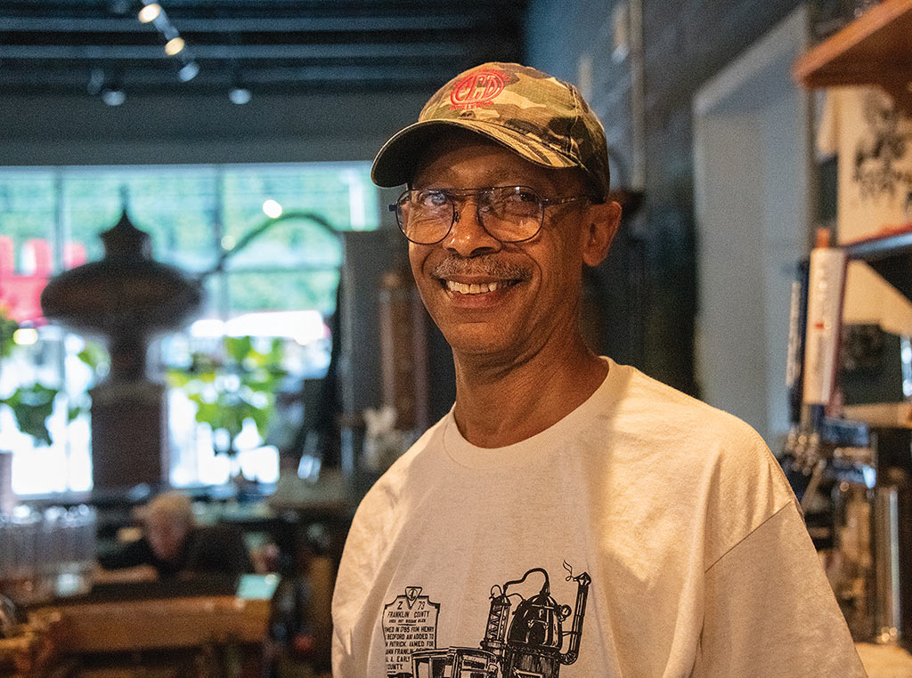 man with baseball cap and glasses smiling