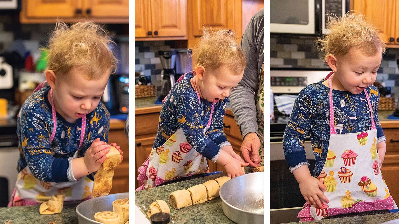 little girl making cinnamon rolls in kitchen