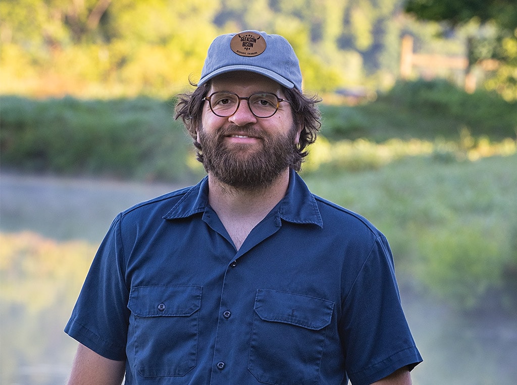 man with baseball cap and glasses smiling