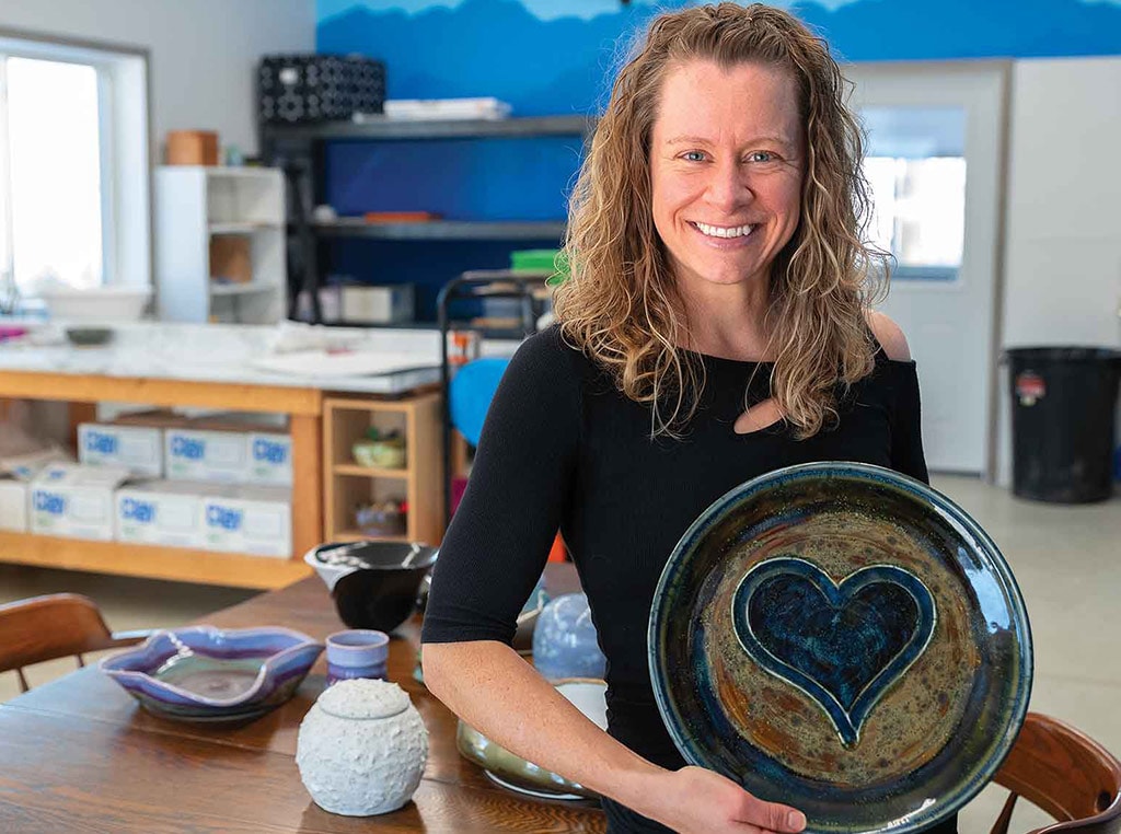 woman holding stoneware plate with heart in the middle