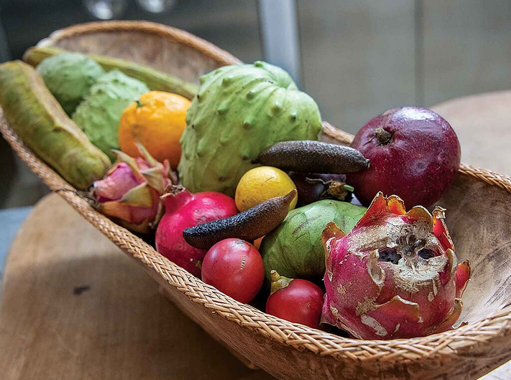 long woven bowl of various exotic fruit