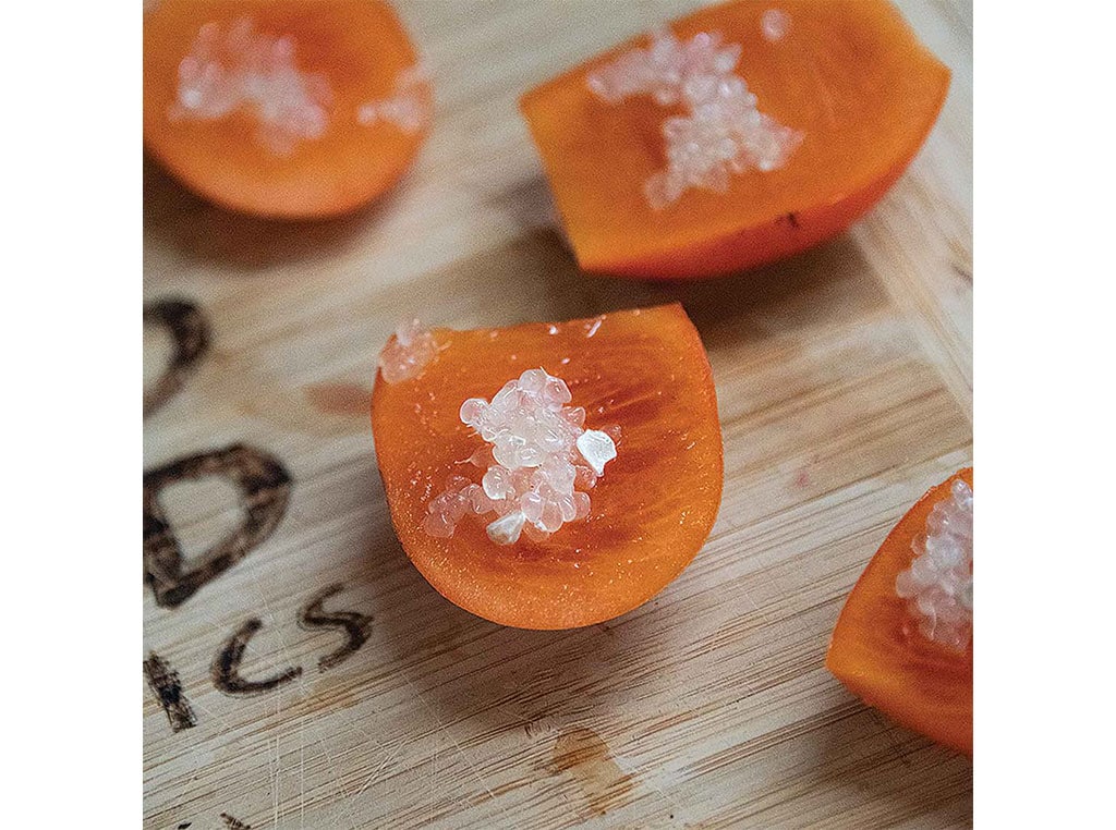 closeup of finger lime on persimmon slices