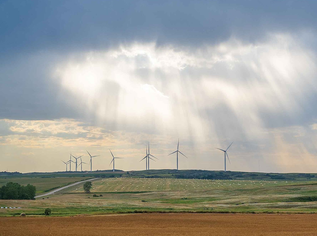 wind turbines with sun gleaming through clouds
