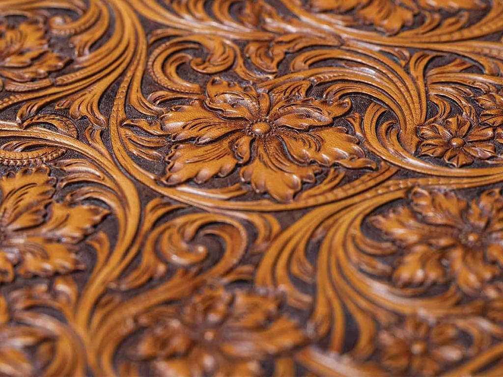 Closeup of intricately carved brown leather in floral pattern