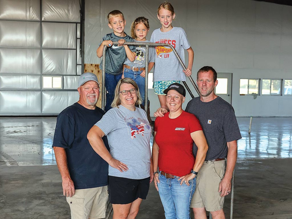 Farming family standing in empty warehouse