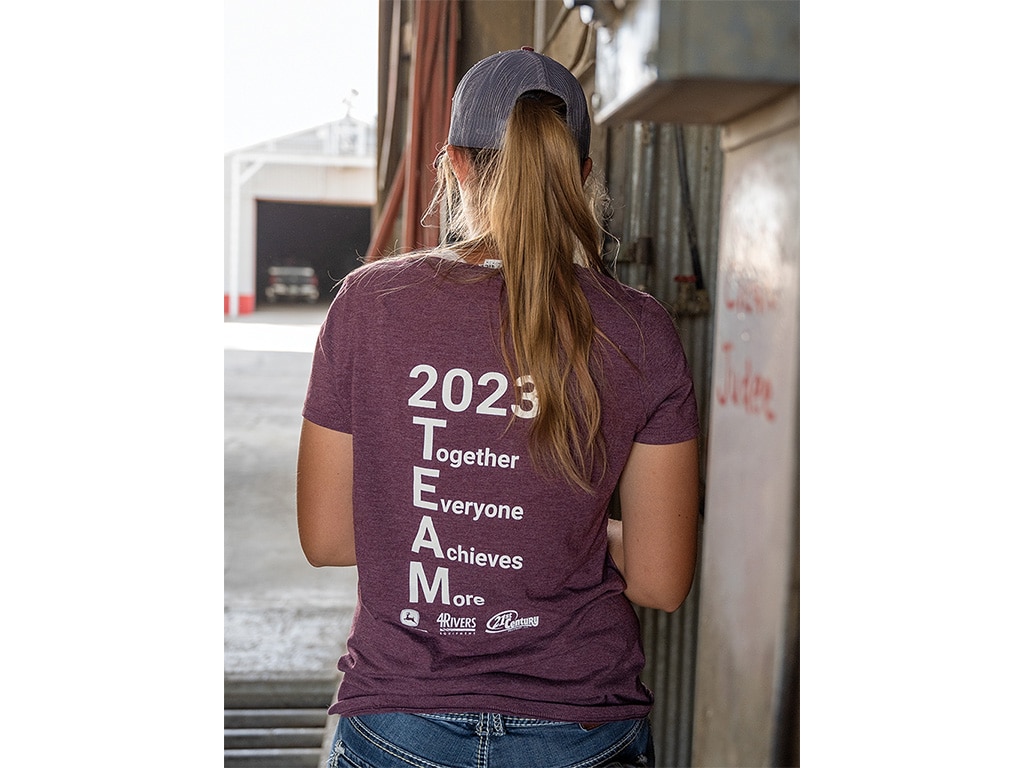young blond woman wearing a shirt that reads Together Everyone Achieves More 2023