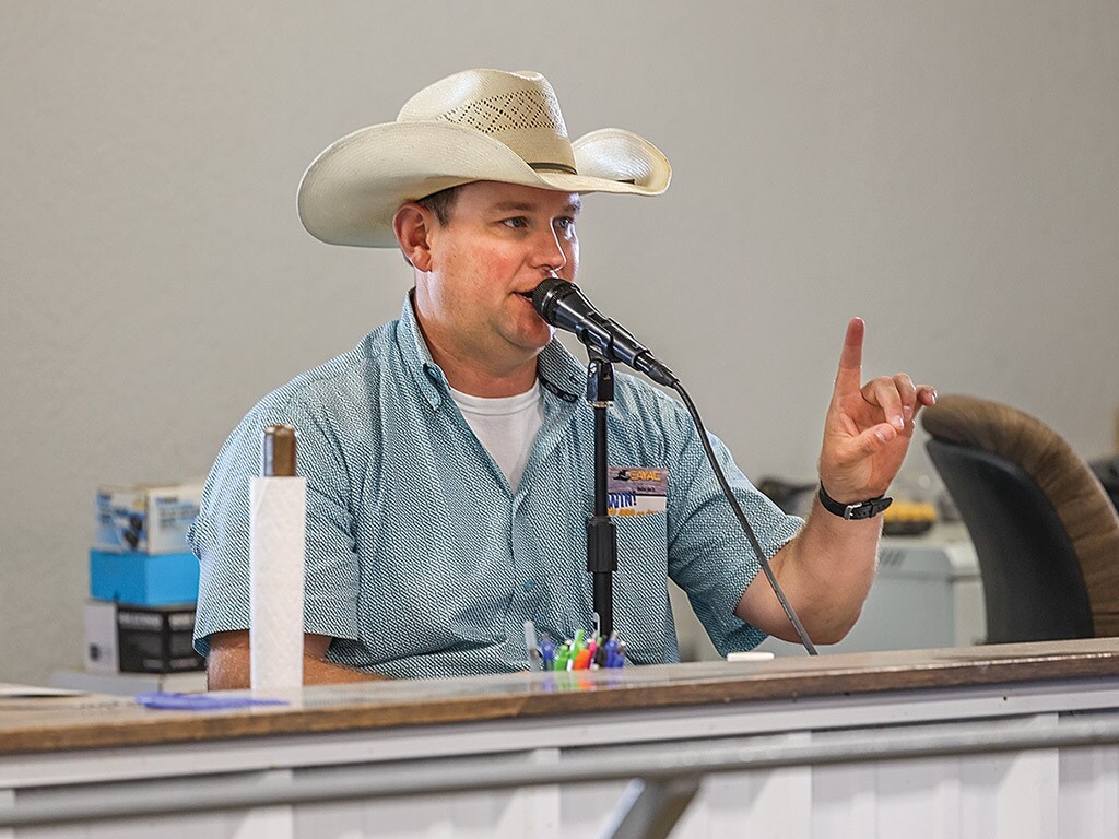 Person speaking into a microphone at an auction