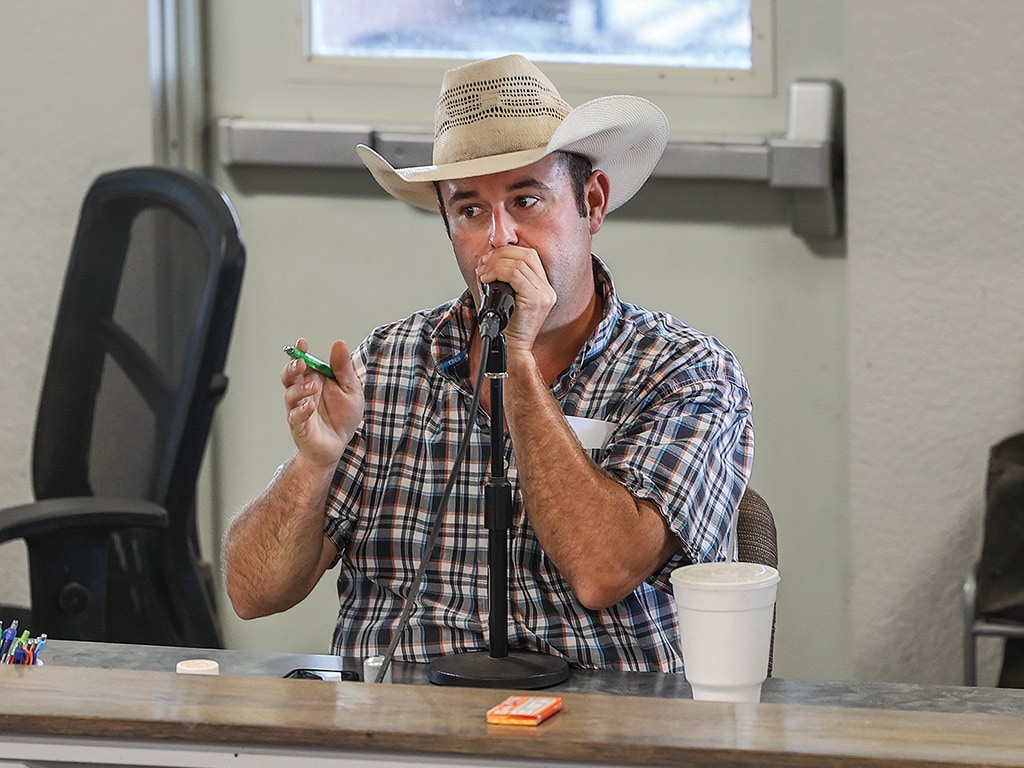 Person speaking into a microphone at an auction