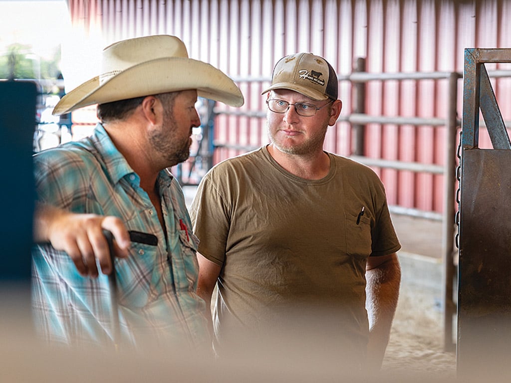 Two people talking in a barn 