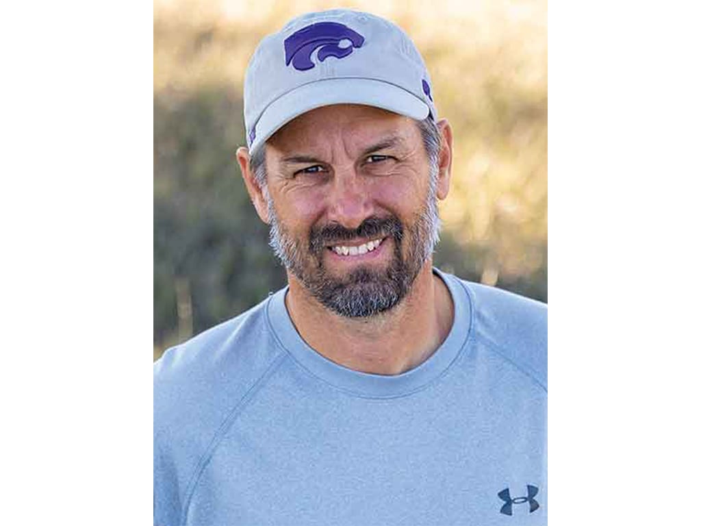 smiling person wearing baseball cap and a beard