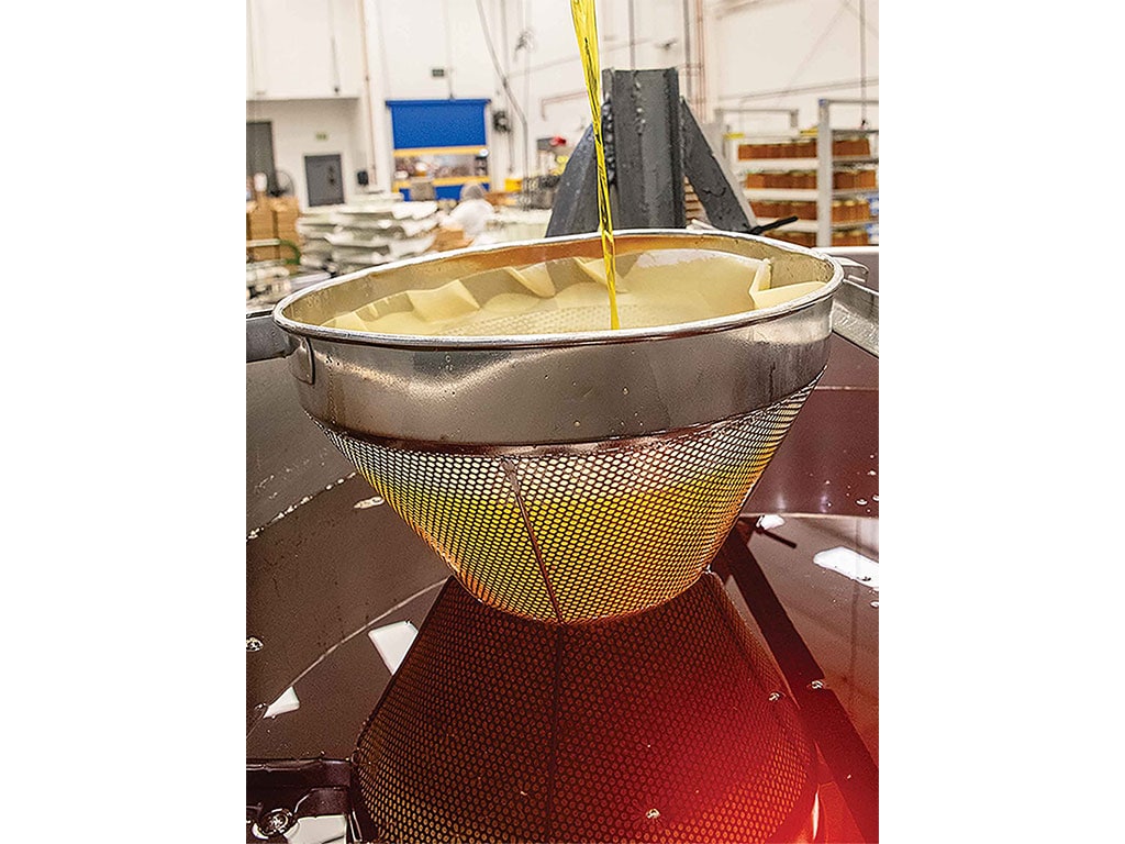 a metal strainer separating the milk solids from the liquid butter