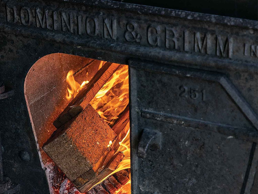 closeup of an iron oven with burning wood inside