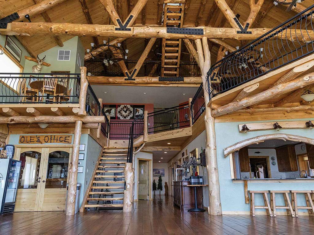 the interior of an ornate lodge with lots of log beams and black hardware
