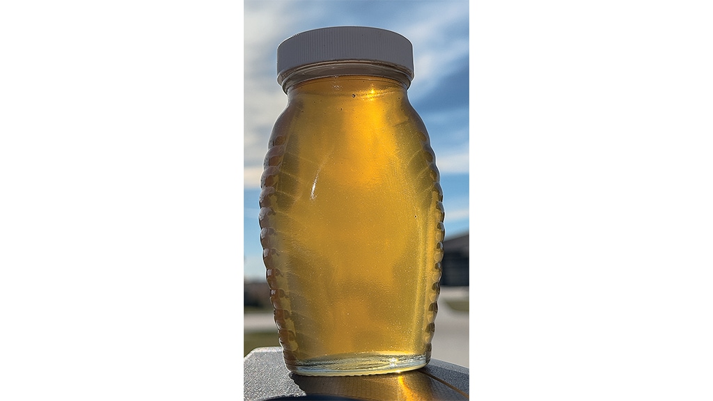 closeup of a jar of honey backlit by sunshine
