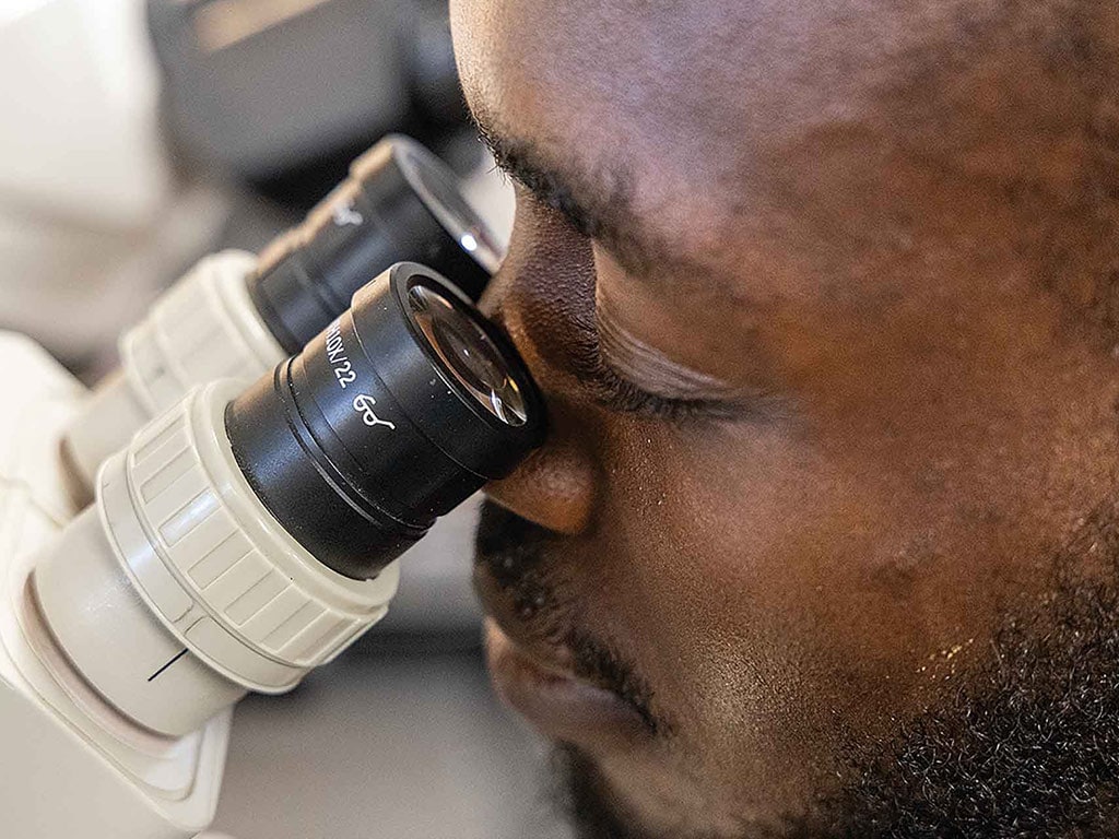 closeup of person looking into microscope