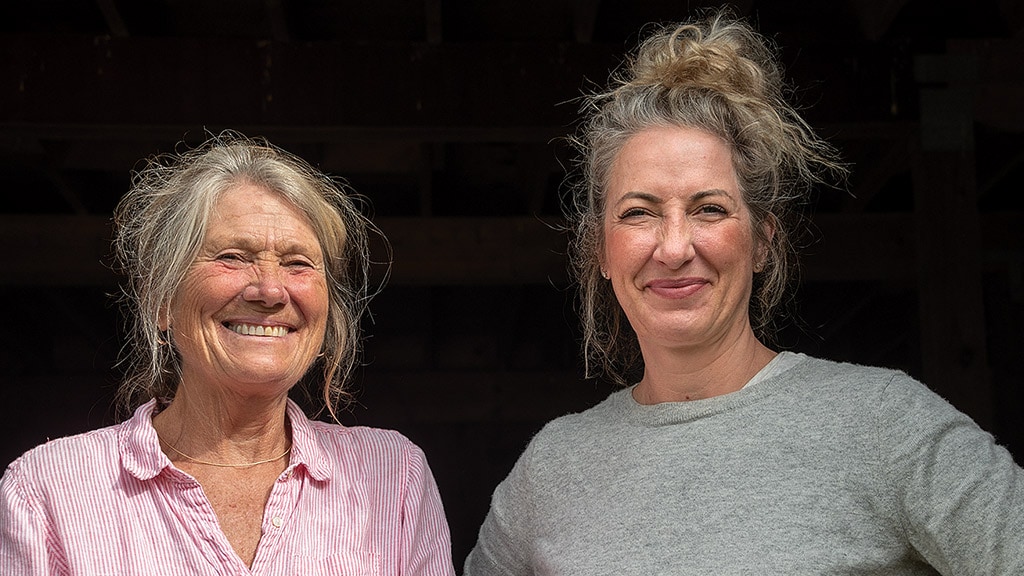 two smiling person in fornt of black background