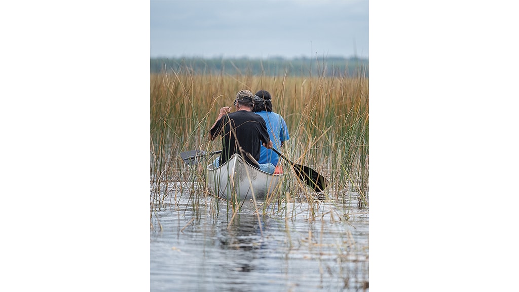 two men rowing kayak in the lake