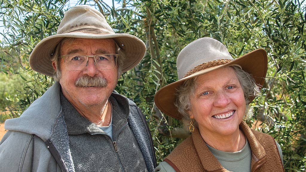 couple with cowboy hat smiling looking at the camera