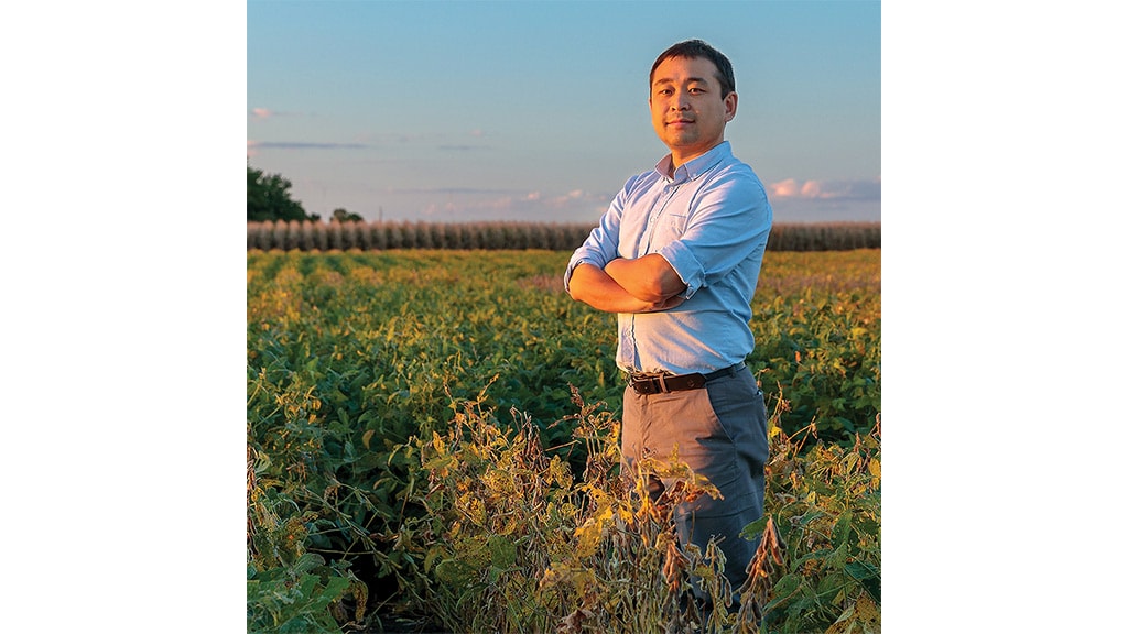 Man folding hand standing in the field posing for a photo