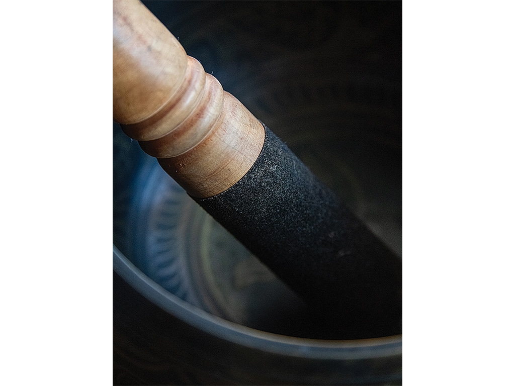 Closeup of a wood-handled, stone antique mortar and pestle