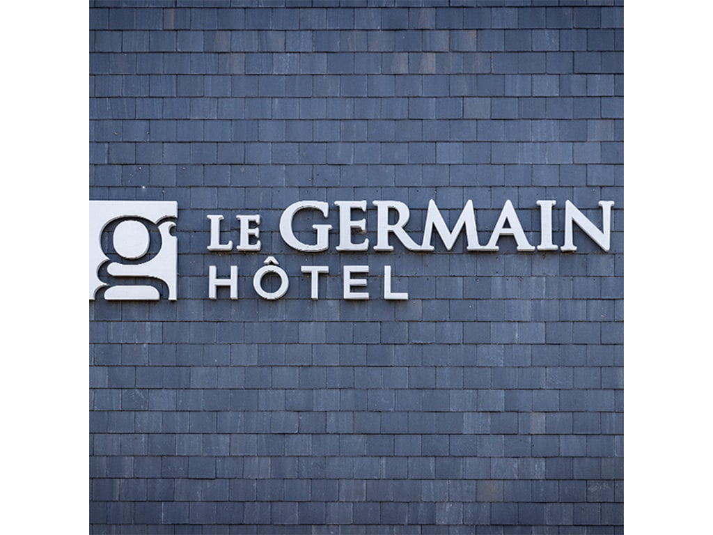 A grey brick wall with a sign reading "LE GERMAIN HÔTEL"
