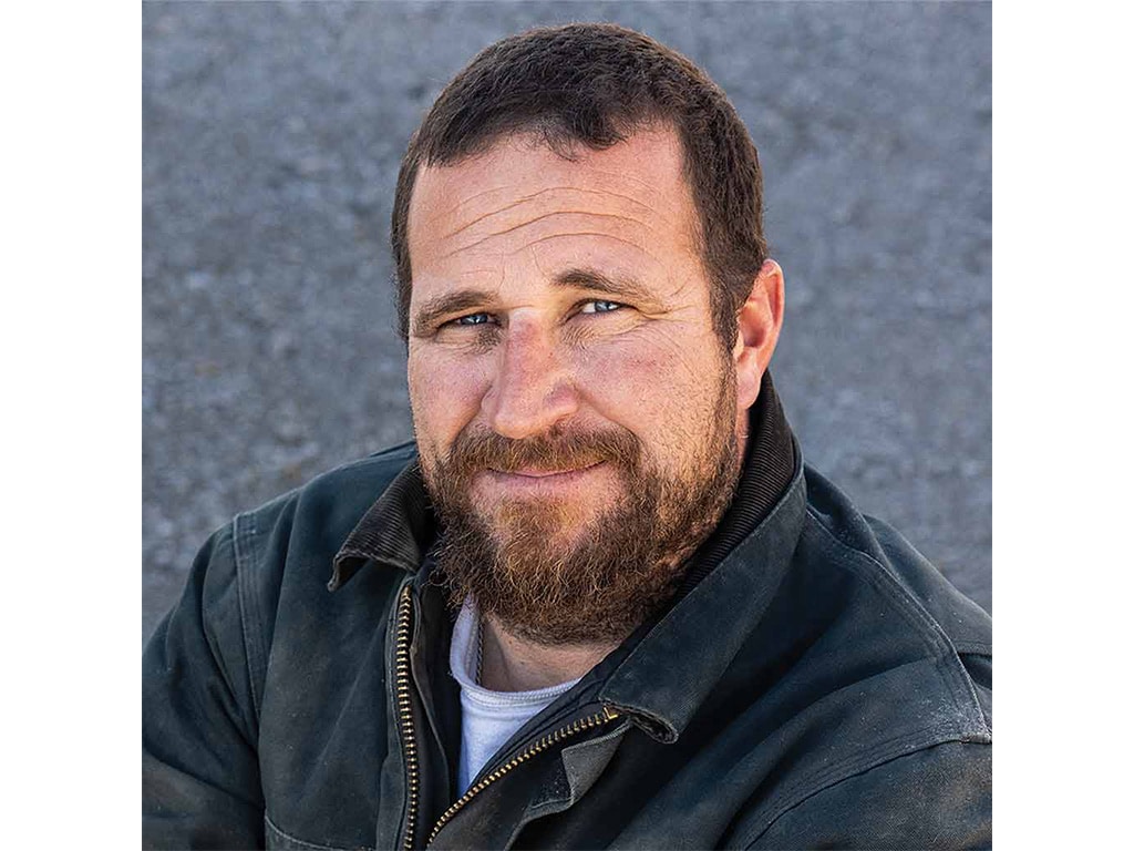 A farmer smiling by concrete road