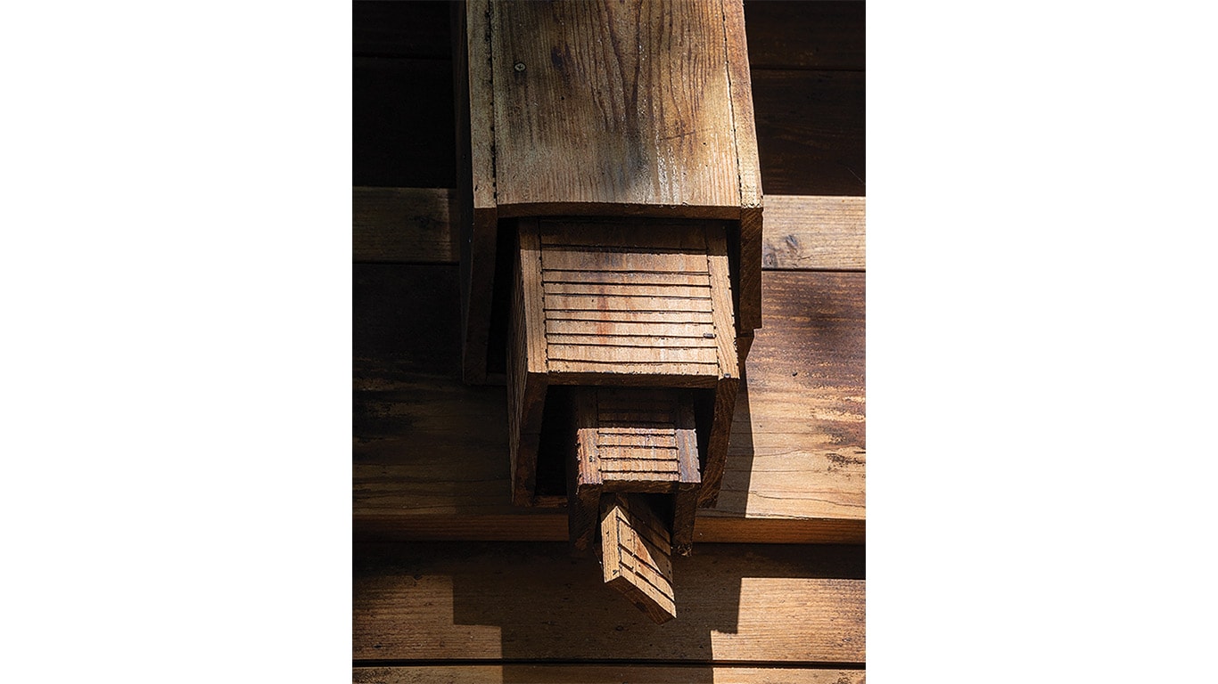 Close-up of intricately carved wooden architectural detail on a structure and a pointed extension.