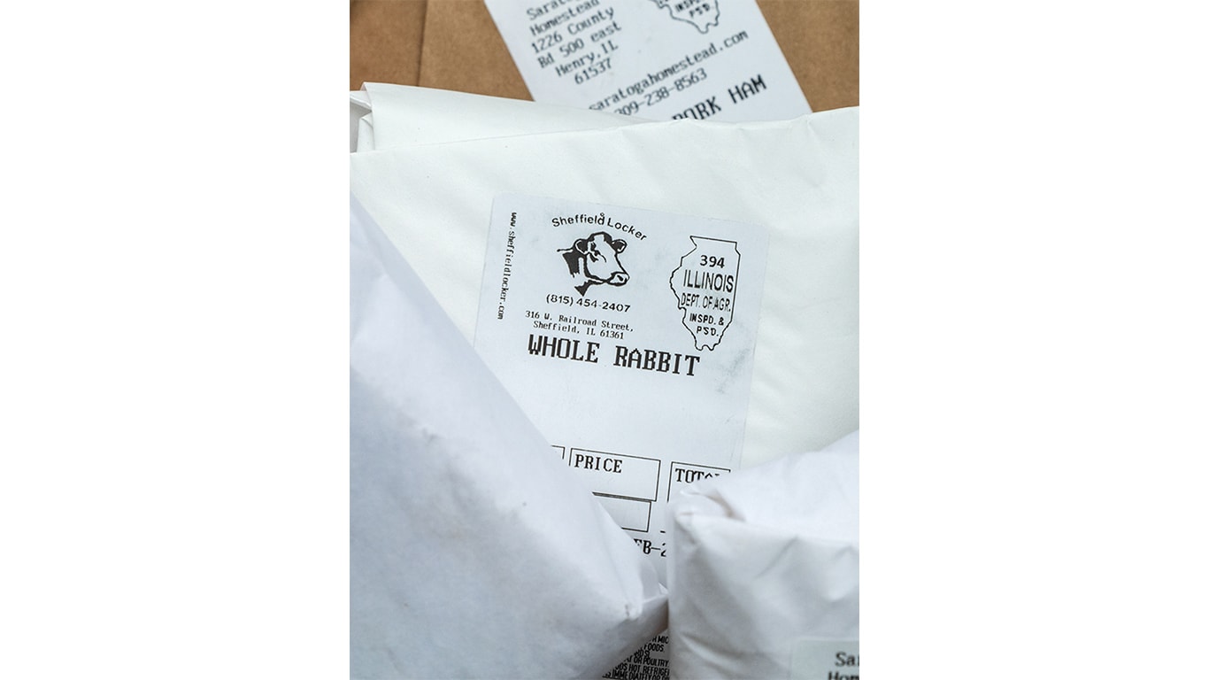 A family selling meat, eggs, and produce at their farm stand.