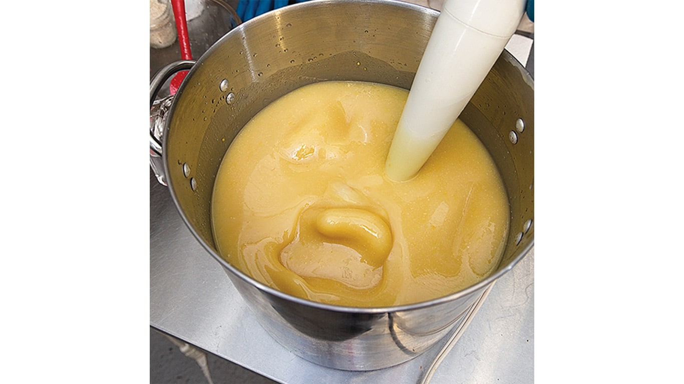 A stainless steel pot filled with thick, creamy yellow mixture.