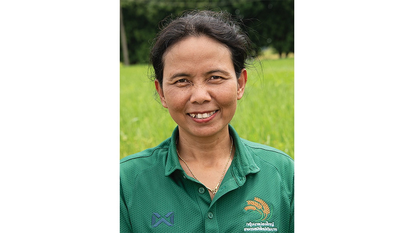 Smiling person wearing a green shirt standing outside