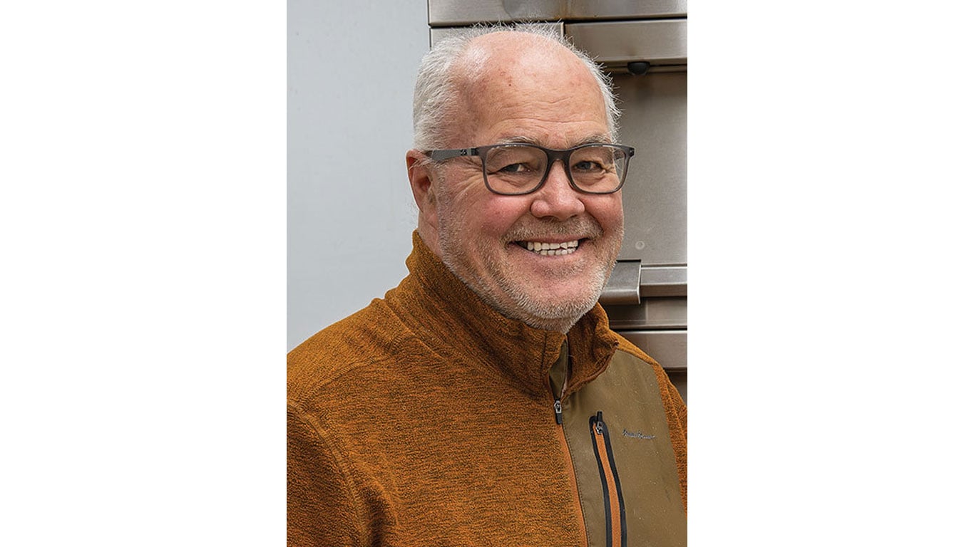 Man with glasses smiling for a portrait picture.