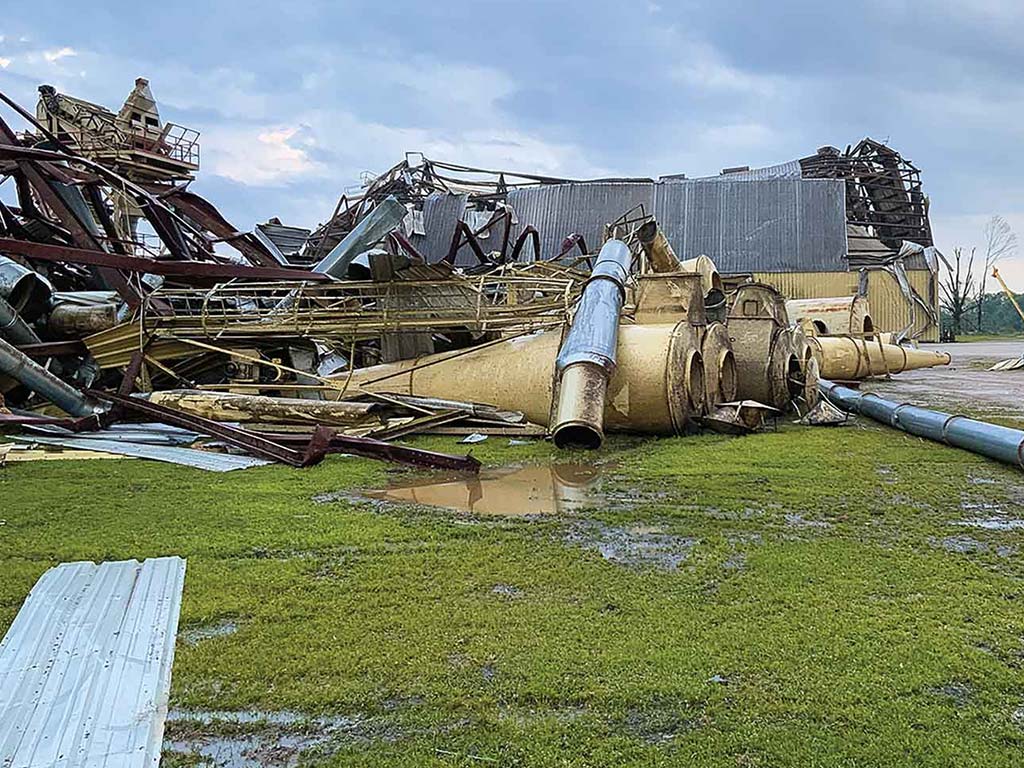 A collapsed industrial building with twisted metal and scattered machinery.