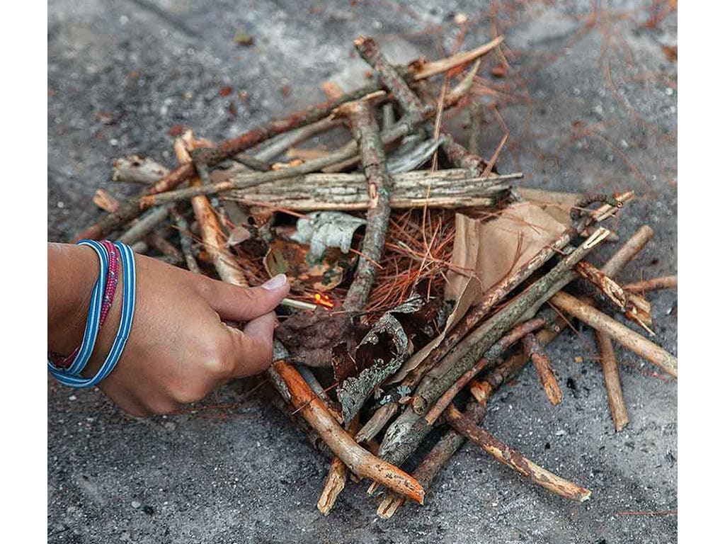Closeup of a small firepit with a hands assembling it
