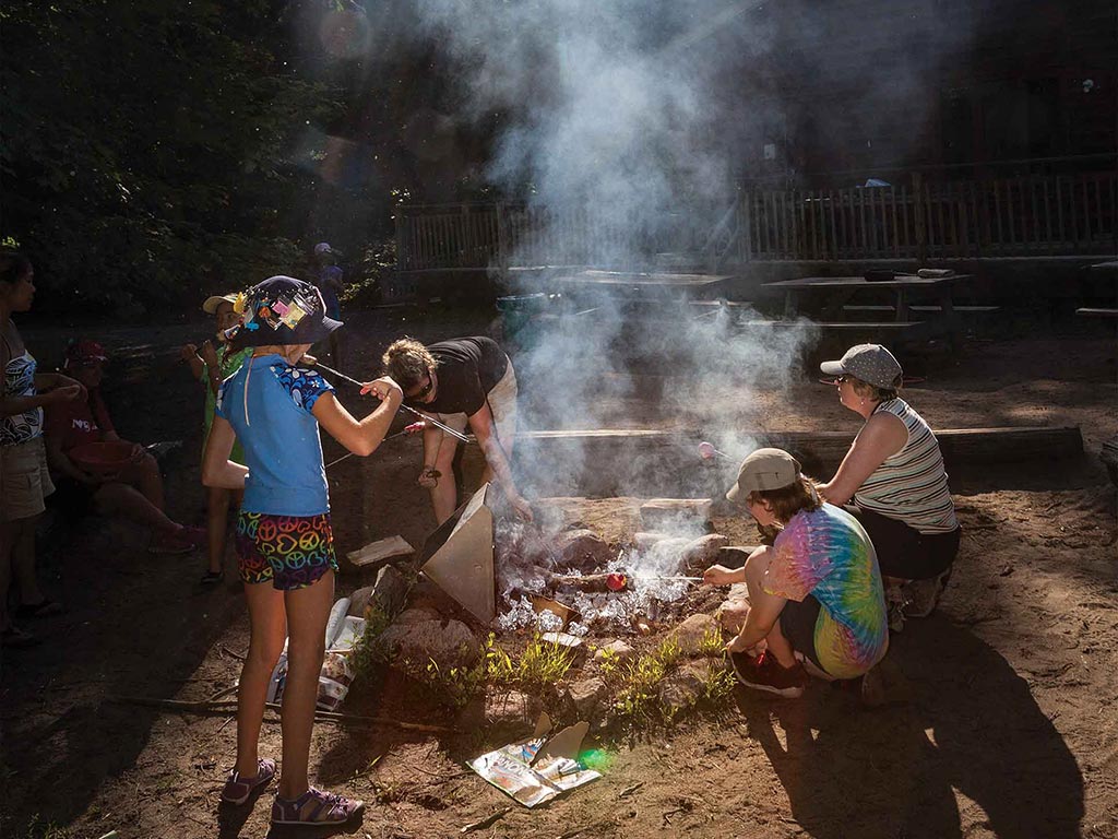 A group of people sitting around firepit in the dark