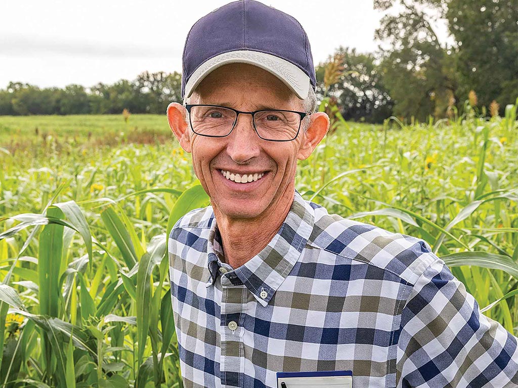 A persion with hat smiling in sunflower field